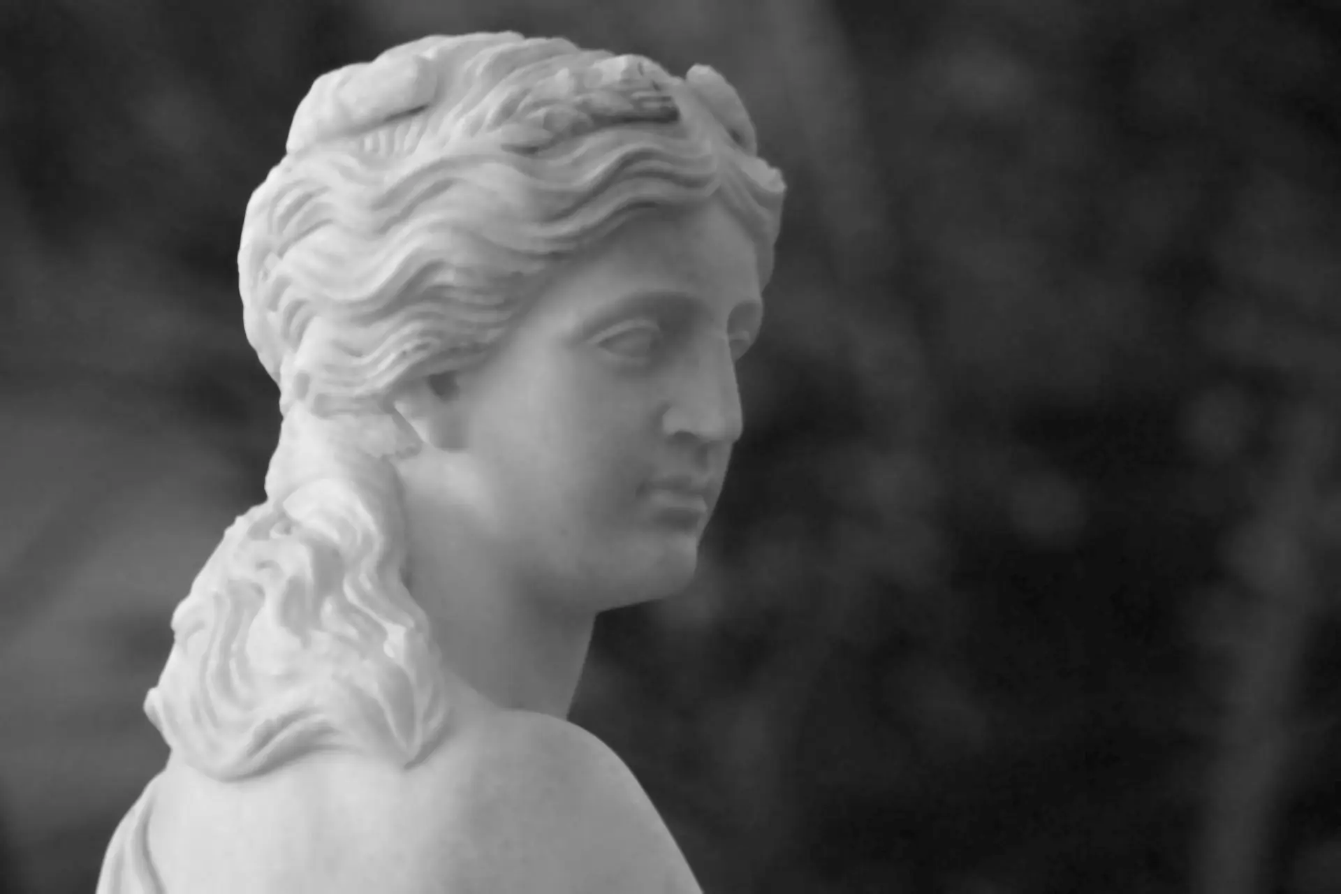 a black and white photo of a statue of a woman
